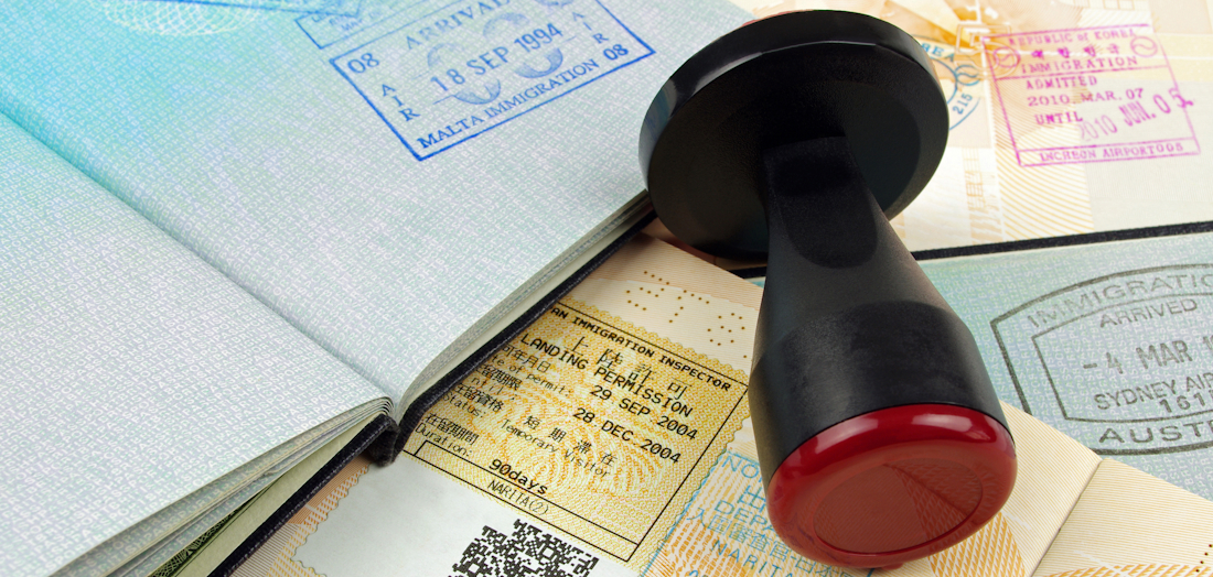 Visa stamper resting on various opened passports